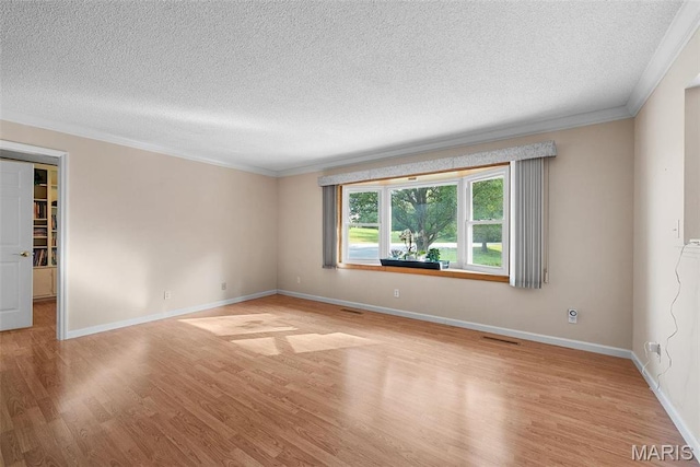empty room featuring crown molding, a textured ceiling, light wood-style floors, and baseboards