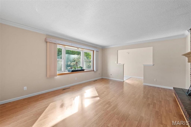 unfurnished living room featuring crown molding, light wood-style floors, a textured ceiling, baseboards, and a fireplace