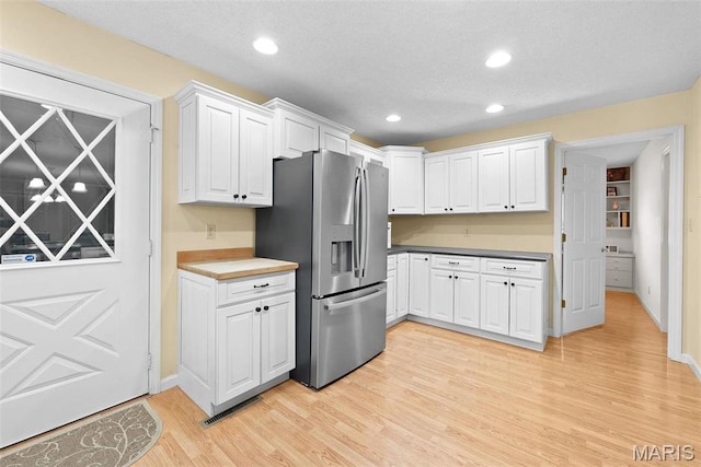 kitchen with stainless steel fridge with ice dispenser, light wood-style floors, white cabinets, recessed lighting, and baseboards