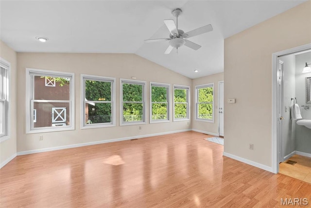 unfurnished living room featuring a ceiling fan, light wood-style floors, vaulted ceiling, and baseboards