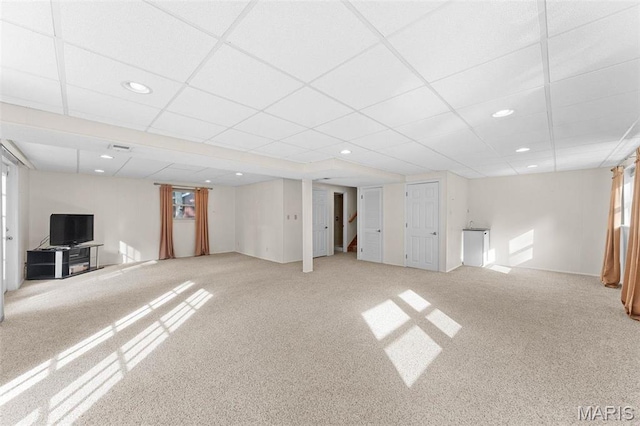 basement featuring light colored carpet, recessed lighting, and a drop ceiling