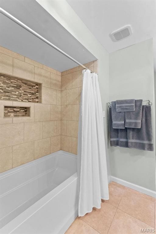 bathroom featuring tile patterned floors, baseboards, and shower / tub combo