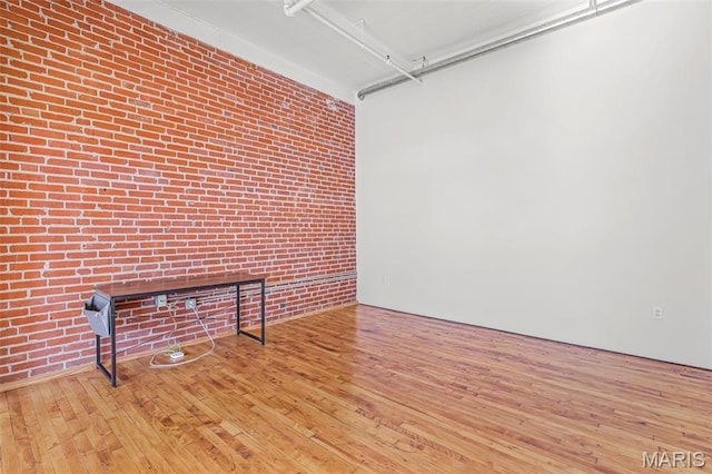 1010 Saint Charles St Unit 803, Saint Louis, MO 63101 - unfurnished living room with hardwood / wood-style flooring and brick wall