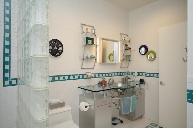 1010 Saint Charles St Unit 802, Saint Louis, MO 63101 - bathroom featuring tile walls, a sink, wainscoting, toilet, and tile patterned floors