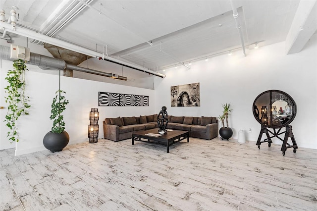 living area with rail lighting and wood finished floors