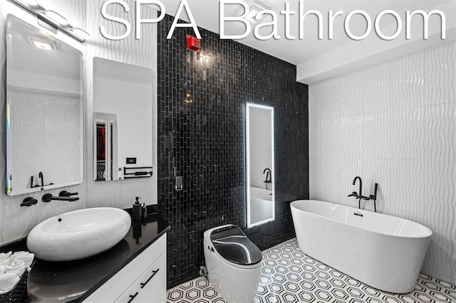 bathroom with tile walls, a soaking tub, vanity, and tile patterned floors