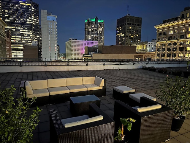 patio at twilight featuring an outdoor hangout area and a view of city lights