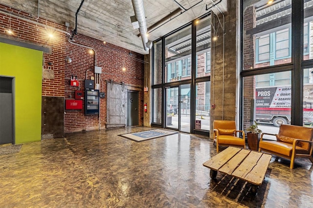 community lobby with a towering ceiling and brick wall
