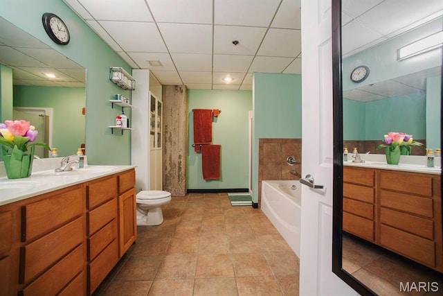 bathroom with a paneled ceiling, double vanity, a garden tub, toilet, and a shower