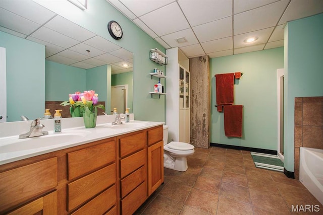 bathroom with a paneled ceiling, toilet, a bath, double vanity, and a shower