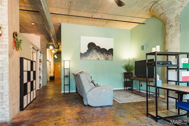 sitting room featuring concrete floors and ceiling fan
