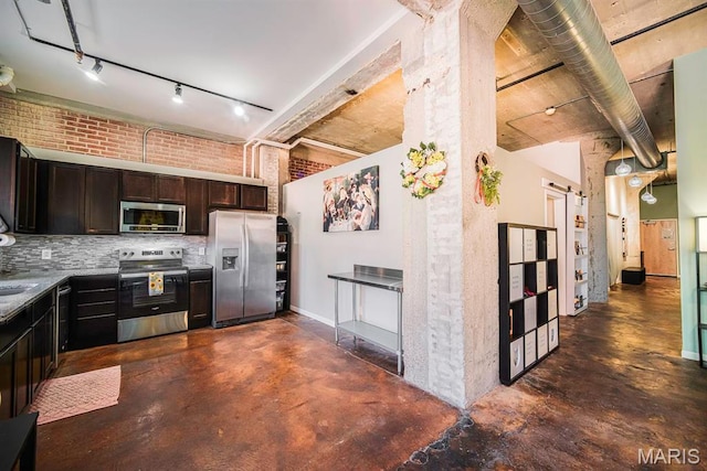 kitchen with stainless steel appliances, finished concrete flooring, track lighting, dark brown cabinets, and decorative backsplash