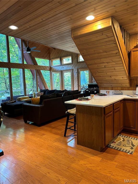 2359 Kitzbuhl Way S, Innsbrook, MO 63390 - kitchen with open floor plan, wood ceiling, brown cabinets, a kitchen breakfast bar, and light countertops