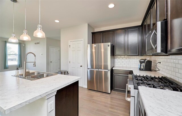 120 Kelcross, Wentzville, MO 63385 - kitchen with stainless steel appliances, a sink, light wood-style floors, backsplash, and light countertops