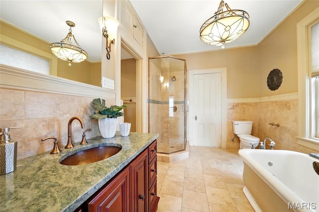 full bath with toilet, vanity, a shower stall, a bath, and tile walls