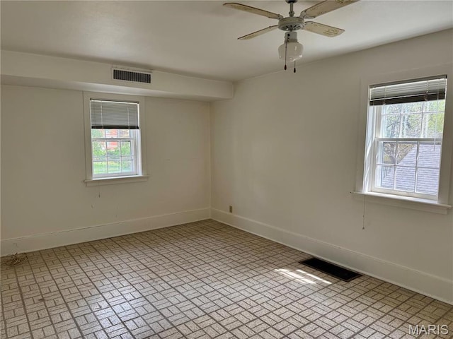 empty room featuring plenty of natural light, baseboards, and ceiling fan