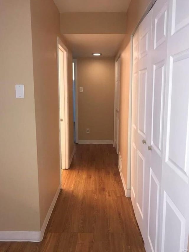hallway with wood finished floors and baseboards