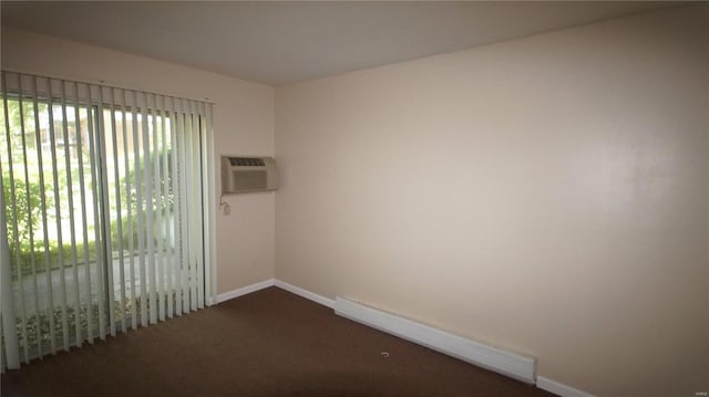 empty room featuring a wall mounted air conditioner, carpet floors, and baseboards