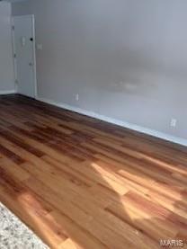 unfurnished room with wood finished floors and baseboards