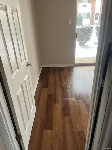 hallway featuring baseboards and wood finished floors