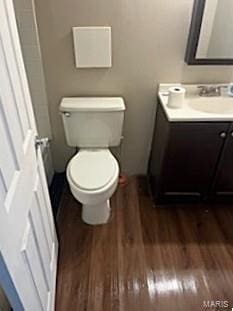 bathroom with wood finished floors, toilet, and vanity