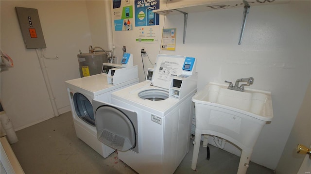 laundry area featuring water heater, washing machine and dryer, a sink, and electric panel