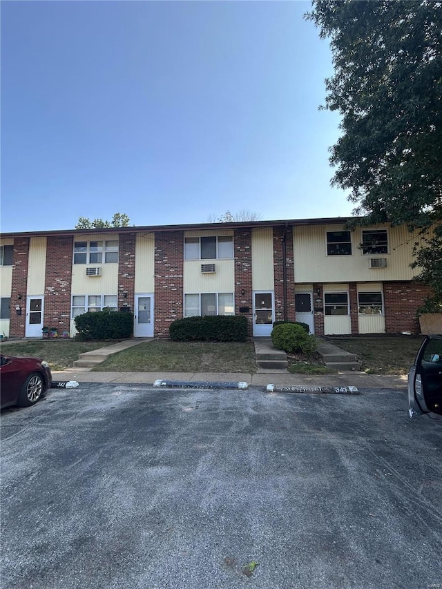 view of front of property featuring brick siding and uncovered parking