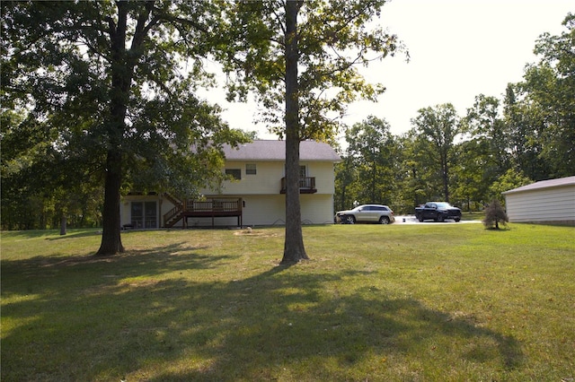 view of green lawn featuring stairway and a deck