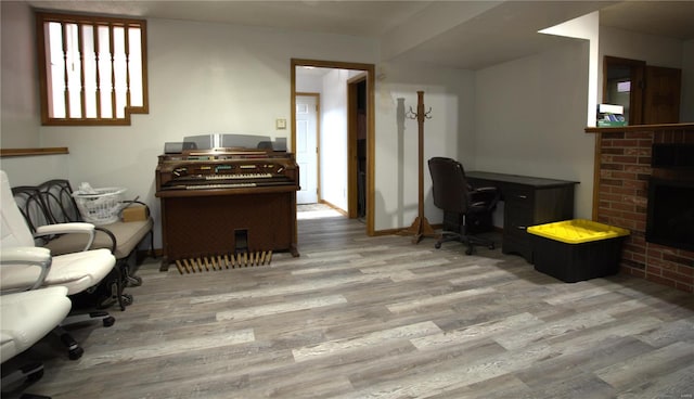 living room with wood finished floors, a fireplace, an office area, and baseboards
