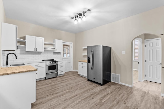 4634 Tyrolean Ave, Saint Louis, MO 63116 - kitchen featuring open shelves, stainless steel appliances, a sink, wooden counters, and light wood-type flooring