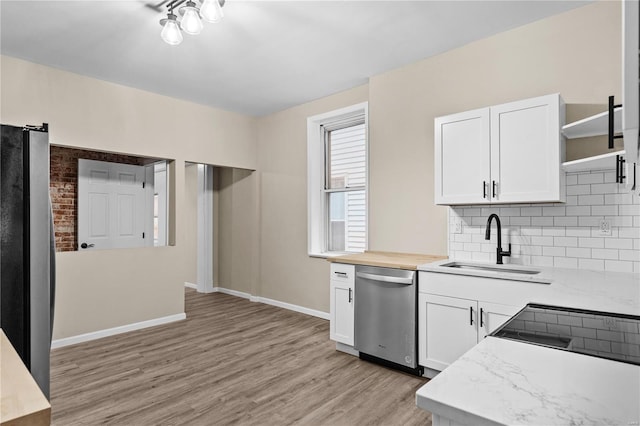 4634 Tyrolean Ave, Saint Louis, MO 63116 - kitchen with stainless steel appliances, open shelves, a sink, light wood finished floors, and backsplash
