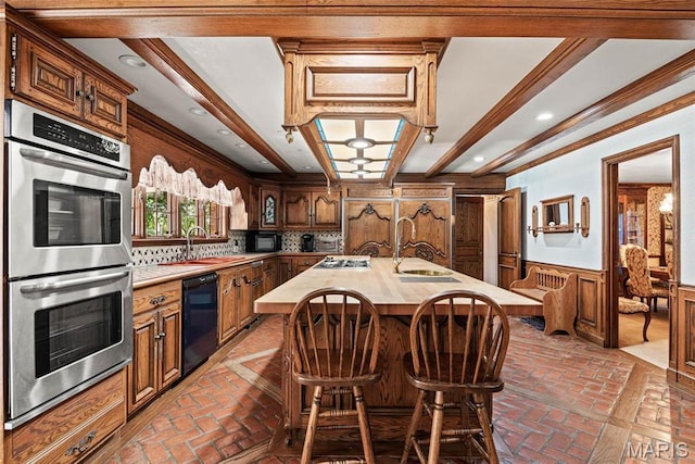3112 Parkview Dr, Granite City, IL 62040 - kitchen with stainless steel appliances, a wainscoted wall, brick flooring, a center island with sink, and backsplash