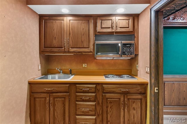 3112 Parkview Dr, Granite City, IL 62040 - kitchen with brown cabinets, stovetop, light countertops, and a textured wall