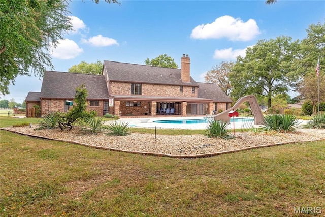 3112 Parkview Dr, Granite City, IL 62040 - rear view of property with a chimney, a yard, an outdoor pool, and brick siding