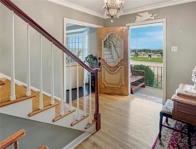 520 N Main St, Louisiana, MO 63353 - entryway featuring healthy amount of natural light, stairway, wood finished floors, crown molding, and a chandelier
