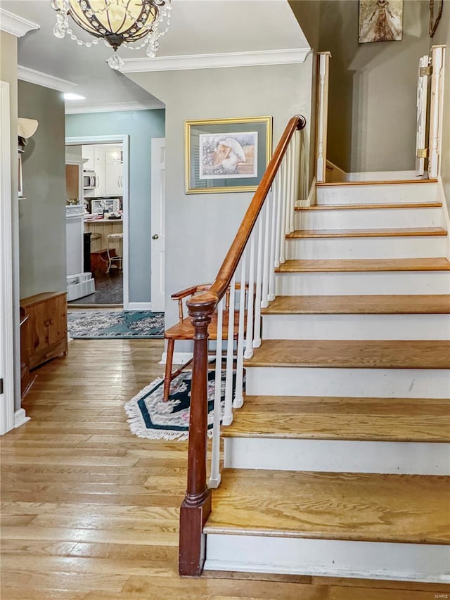 520 N Main St, Louisiana, MO 63353 - stairs featuring crown molding, hardwood / wood-style floors, and a chandelier