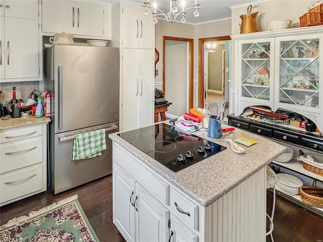 520 N Main St, Louisiana, MO 63353 - kitchen with freestanding refrigerator, black electric stovetop, a chandelier, ornamental molding, and dark wood-type flooring