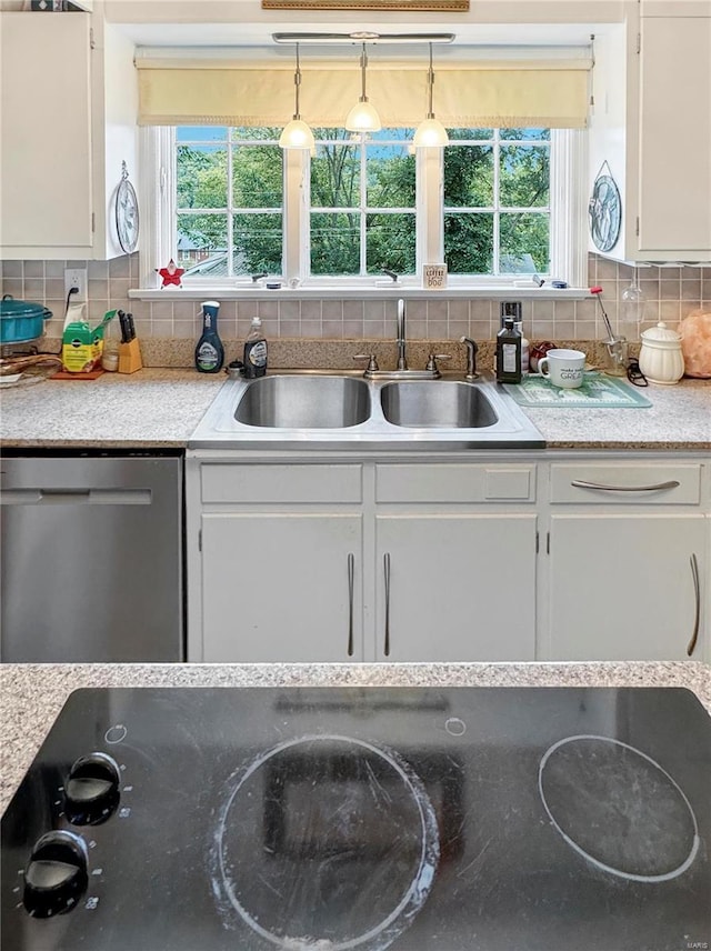 520 N Main St, Louisiana, MO 63353 - kitchen with stainless steel dishwasher, a sink, white cabinetry, and healthy amount of natural light