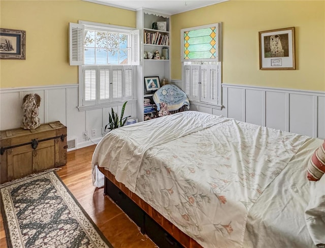 520 N Main St, Louisiana, MO 63353 - bedroom with wainscoting, a decorative wall, and wood finished floors
