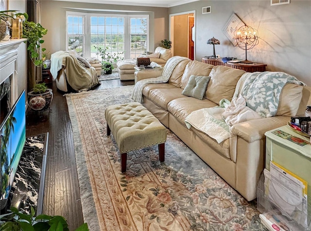 520 N Main St, Louisiana, MO 63353 - living area featuring crown molding, wood finished floors, a fireplace, and a chandelier