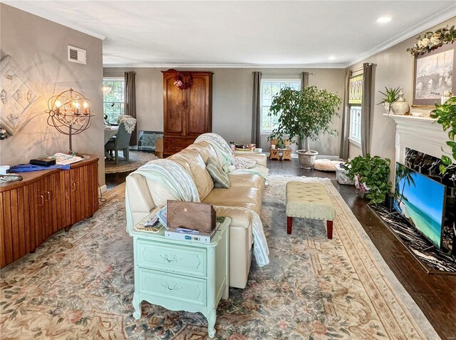 520 N Main St, Louisiana, MO 63353 - living area featuring healthy amount of natural light, wood finished floors, ornamental molding, a chandelier, and a premium fireplace