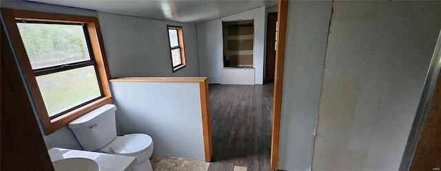 bathroom with plenty of natural light, toilet, wood finished floors, and lofted ceiling