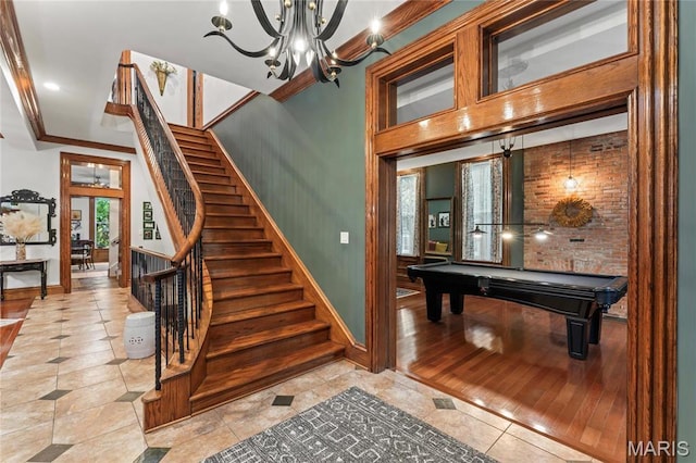 3623 Ohio Ave, Saint Louis, MO 63118 - staircase featuring tile patterned flooring, crown molding, a chandelier, and pool table