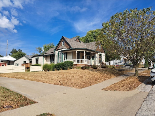 324 N Main St, Palmyra, MO 63461 - view of front of home with covered porch, fence, and a shingled roof