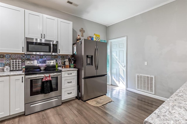310 Crane St, Park Hills, MO 63601 - kitchen featuring stainless steel appliances, backsplash, wood finished floors, white cabinetry, and crown molding