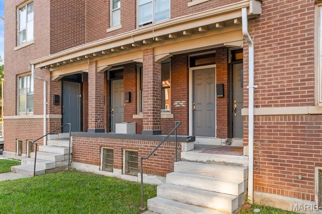 view of exterior entry featuring brick siding
