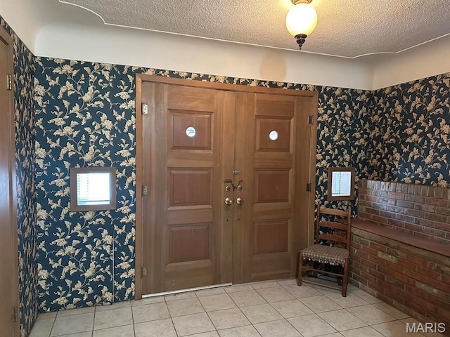 16347 Crestview Dr, Dexter, MO 63841 - entryway featuring light tile patterned flooring, wallpapered walls, and a textured ceiling