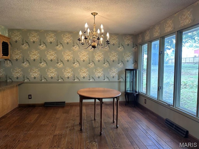16347 Crestview Dr, Dexter, MO 63841 - dining area featuring dark wood-style flooring, a textured ceiling, a chandelier, and wallpapered walls