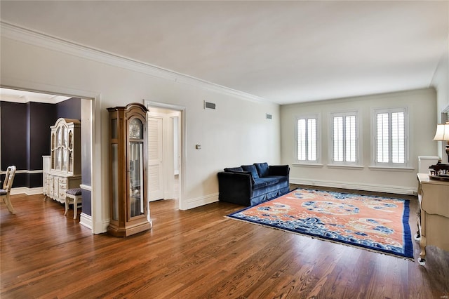 living room with wood finished floors, crown molding, and baseboards
