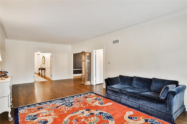 living room with wood finished floors, ornamental molding, and baseboards